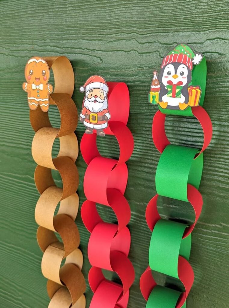 cf81a2b030f8dc3a79afbb4427b20b4e Festive holiday paper chains with cute characters: gingerbread man, Santa Claus, and penguin, hanging against a green background. | Sky Rye Design Festive holiday paper chains with cute characters: gingerbread man, Santa Claus, and penguin, hanging against a green background.