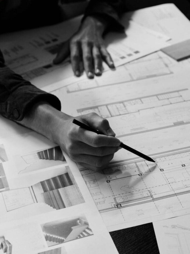 ebf1c04e328333770dcbaa45869bc73c Architect drafting design plans with pencil on paper, surrounded by images and diagrams, showcasing creative architectural process. | Sky Rye Design Architect drafting design plans with pencil on paper, surrounded by images and diagrams, showcasing creative architectural process.