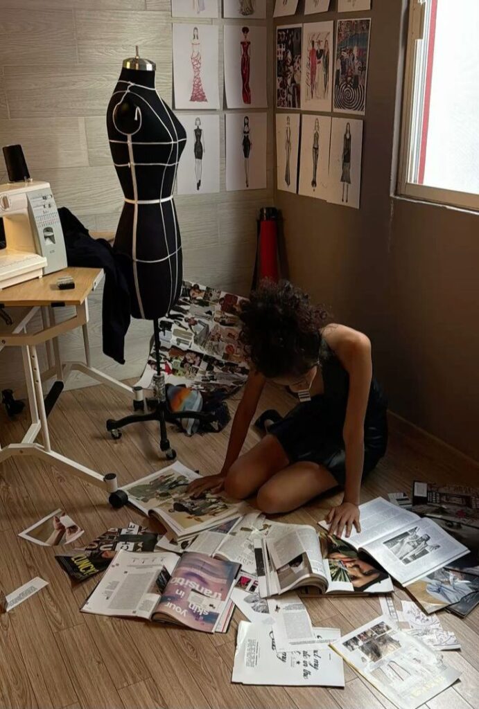 ee4e434c-ff48-44ef-acd9-9ef5d2d4e953 Fashion designer researching with magazines on the floor, surrounded by sketches and a mannequin in a creative studio. | Sky Rye Design Fashion designer researching with magazines on the floor, surrounded by sketches and a mannequin in a creative studio.