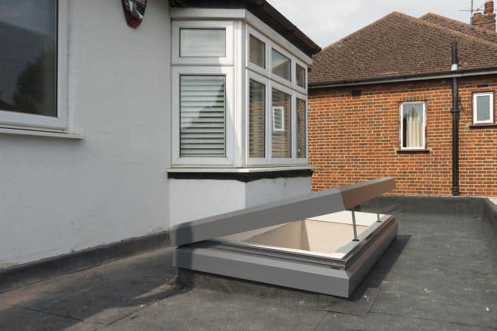 electric-opening-rooflight_home_10_e0_large Modern roof access hatch open on flat rooftop next to windows, surrounded by brick buildings. | Sky Rye Design Modern roof access hatch open on flat rooftop next to windows, surrounded by brick buildings.