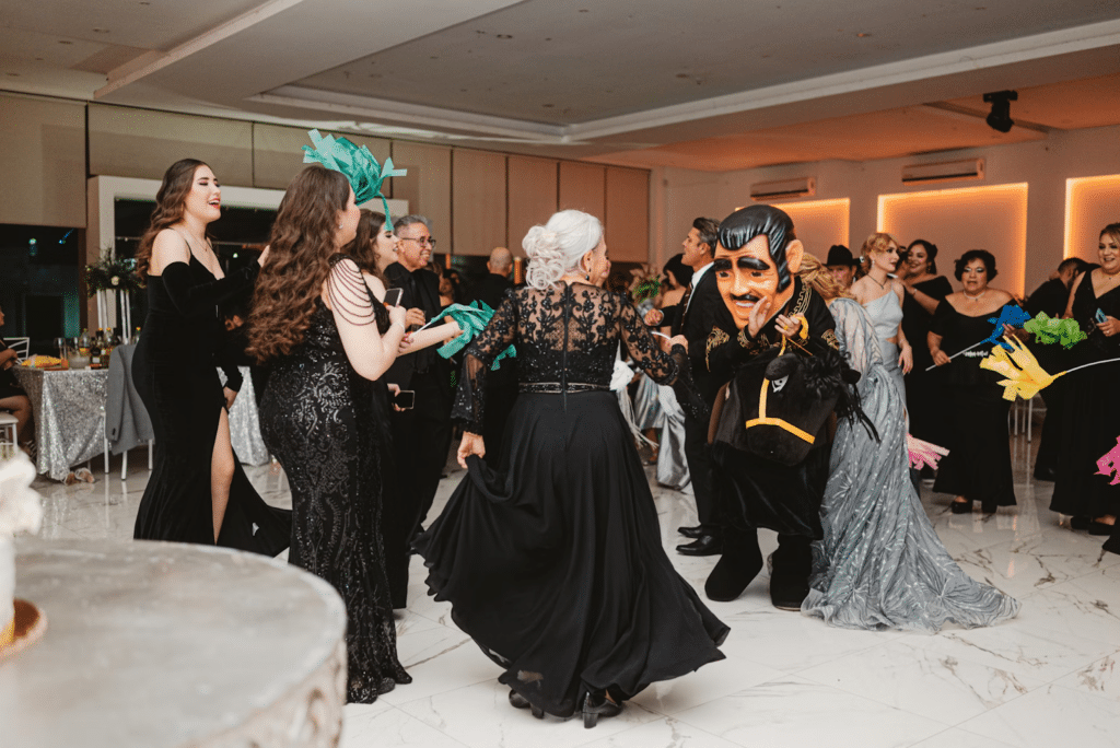 Group of people enjoying a lively party with festive costumes and colorful decorations in an elegant indoor setting.
