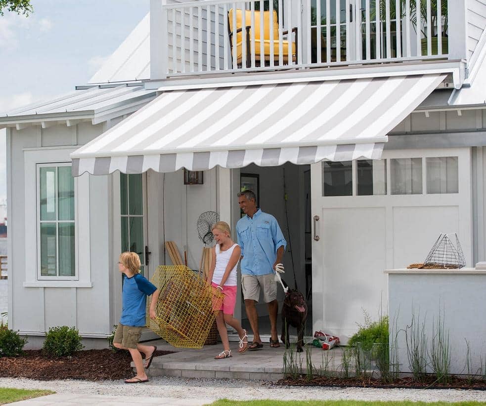 image Family with dog exits seaside home under striped awning, carrying fishing gear. Coastal lifestyle and outdoor fun on a sunny day. | Sky Rye Design Family with dog exits seaside home under striped awning, carrying fishing gear. Coastal lifestyle and outdoor fun on a sunny day.