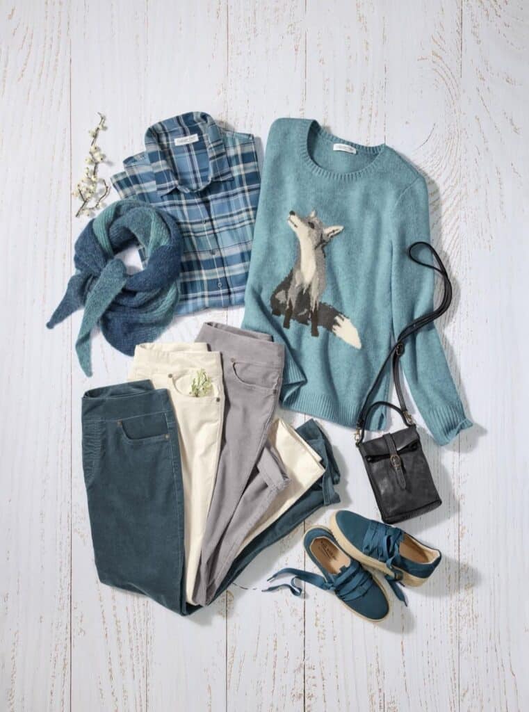 image Casual outfit ensemble with a fox sweater, plaid shirt, scarf, pants, sneakers, and black bag on a wooden floor background. | Sky Rye Design Casual outfit ensemble with a fox sweater, plaid shirt, scarf, pants, sneakers, and black bag on a wooden floor background.