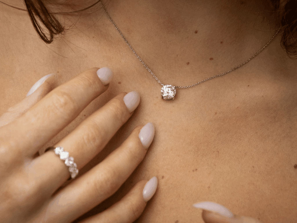 image Elegant diamond necklace and ring showcased on a woman's hand and neck, highlighting luxury jewelry and minimalistic style. | Sky Rye Design Elegant diamond necklace and ring showcased on a woman's hand and neck, highlighting luxury jewelry and minimalistic style.