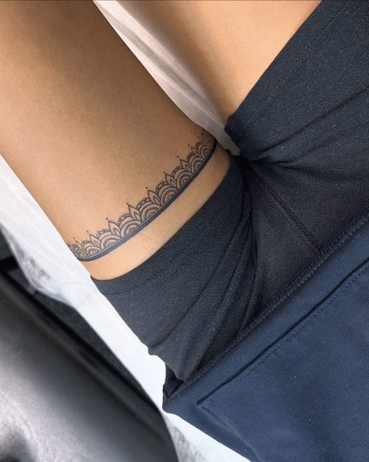 image Intricate lace tattoo design encircles upper thigh, complementing black shorts. Perfect for tattoo design inspiration and fashion. | Sky Rye Design Intricate lace tattoo design encircles upper thigh, complementing black shorts. Perfect for tattoo design inspiration and fashion.