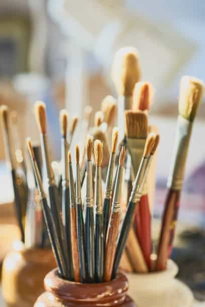 A collection of old sable paintbrushes Assorted paintbrushes in jars, artist's studio setting, natural light. Ideal for creative, art, and painting themes. | Sky Rye Design Assorted paintbrushes in jars, artist's studio setting, natural light. Ideal for creative, art, and painting themes.