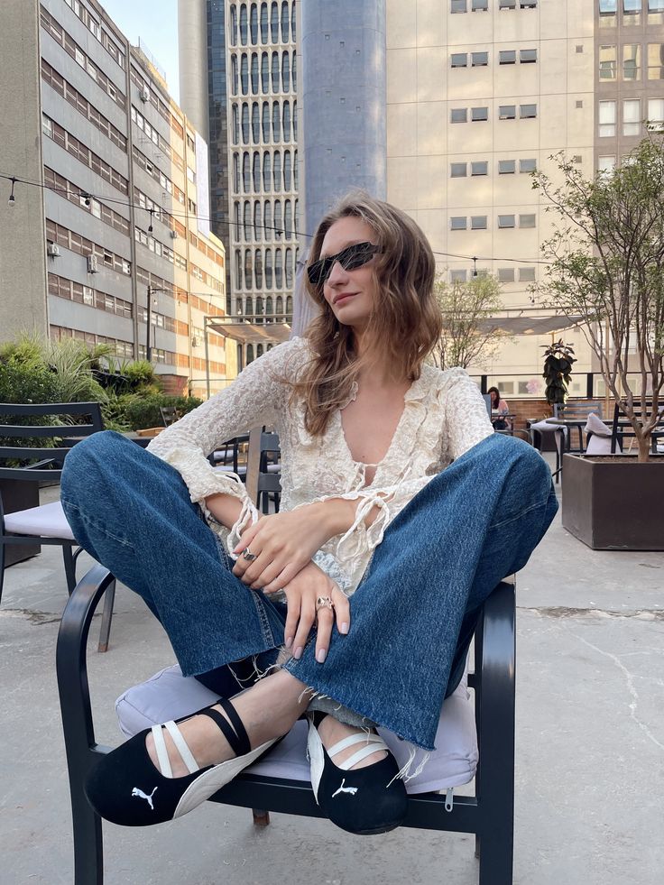 Edited in Tezza with Vintage Temperature Saturation Woman in sunglasses and casual attire sitting on a chair outdoors in an urban setting. | Sky Rye Design Woman in sunglasses and casual attire sitting on a chair outdoors in an urban setting.