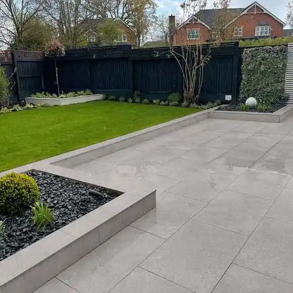 non-slip-porcelain-patio-slabs-uk-garden-paving Modern backyard design with sleek paving, lush green lawn, and minimalist landscaping elements, ideal for contemporary outdoor living. | Sky Rye Design Modern backyard design with sleek paving, lush green lawn, and minimalist landscaping elements, ideal for contemporary outdoor living.