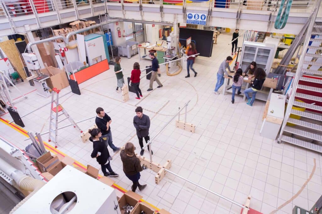 Campagna Ateneo 2015 People collaborating in a dynamic workspace, engaging in creative activities and discussions surrounded by equipment and tools. | Sky Rye Design People collaborating in a dynamic workspace, engaging in creative activities and discussions surrounded by equipment and tools.
