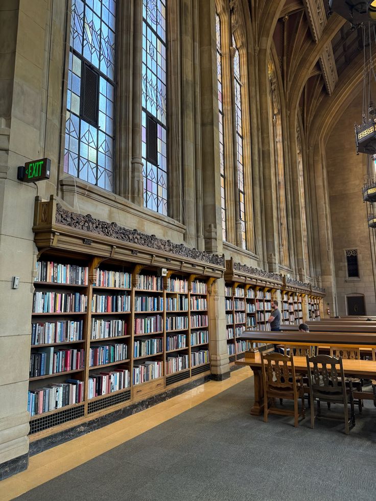 university of washington Elegant library interior with tall stained glass windows, wooden shelves filled with books, and wooden tables for studying. | Sky Rye Design Elegant library interior with tall stained glass windows, wooden shelves filled with books, and wooden tables for studying.