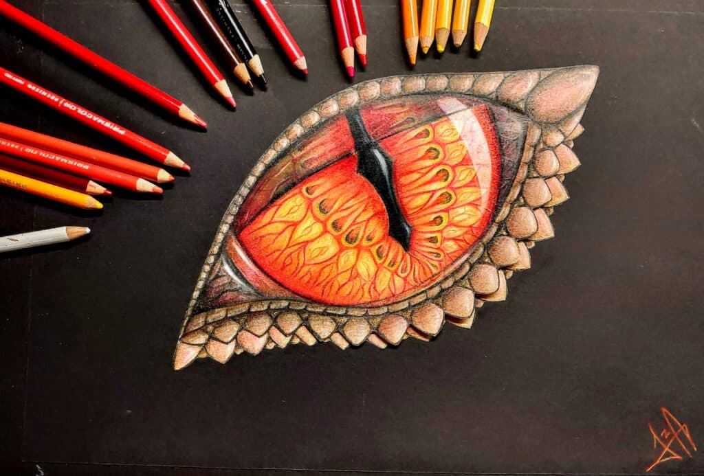 Colored pencils and drawing of a vibrant dragon eye on black paper, showcasing detailed scales and fiery hues. | Sky Rye Design Colored pencils and drawing of a vibrant dragon eye on black paper, showcasing detailed scales and fiery hues.