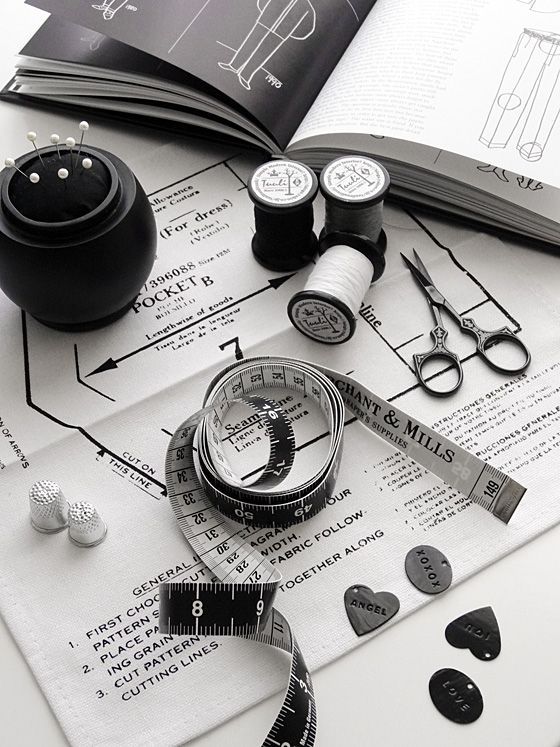 _ Sewing essentials lie on a pattern sheet, featuring thread, scissors, tape measure, and a pin cushion, perfect for tailoring projects. | Sky Rye Design Sewing essentials lie on a pattern sheet, featuring thread, scissors, tape measure, and a pin cushion, perfect for tailoring projects.