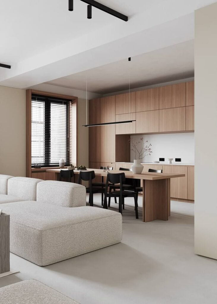_ Modern minimalist living and dining area with beige sofa, wooden table, black chairs, pendant light, and natural wood cabinetry. | Sky Rye Design Modern minimalist living and dining area with beige sofa, wooden table, black chairs, pendant light, and natural wood cabinetry.