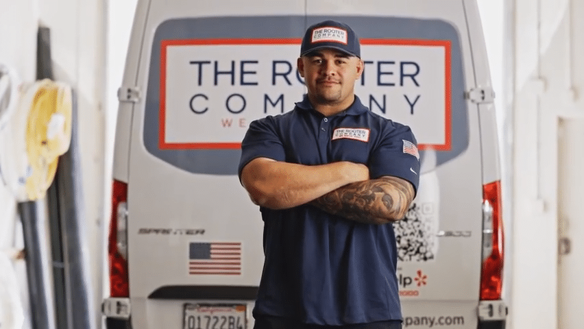 videoframe_3302 Man in uniform with tattoos stands confidently in front of a plumber company van, showcasing professional service and free estimates. | Sky Rye Design Man in uniform with tattoos stands confidently in front of a plumber company van, showcasing professional service and free estimates.