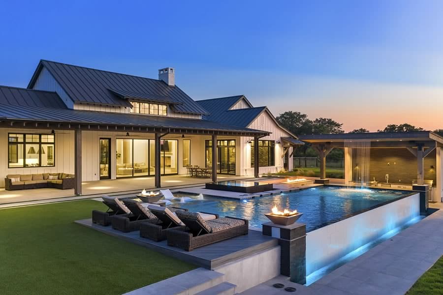 work-custom-built-homes Luxurious modern house with pool, loungers, and outdoor lighting at sunset, showcasing a serene and stylish backyard retreat. | Sky Rye Design Luxurious modern house with pool, loungers, and outdoor lighting at sunset, showcasing a serene and stylish backyard retreat.