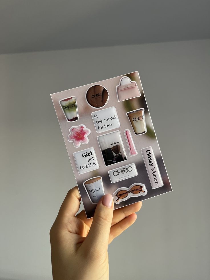 Стикерпаки_ от micecase Hand holding a sheet of stylish stickers with motivational quotes, coffee cups, and fashion items. Perfect for planners and journaling. | Sky Rye Design Hand holding a sheet of stylish stickers with motivational quotes, coffee cups, and fashion items. Perfect for planners and journaling.