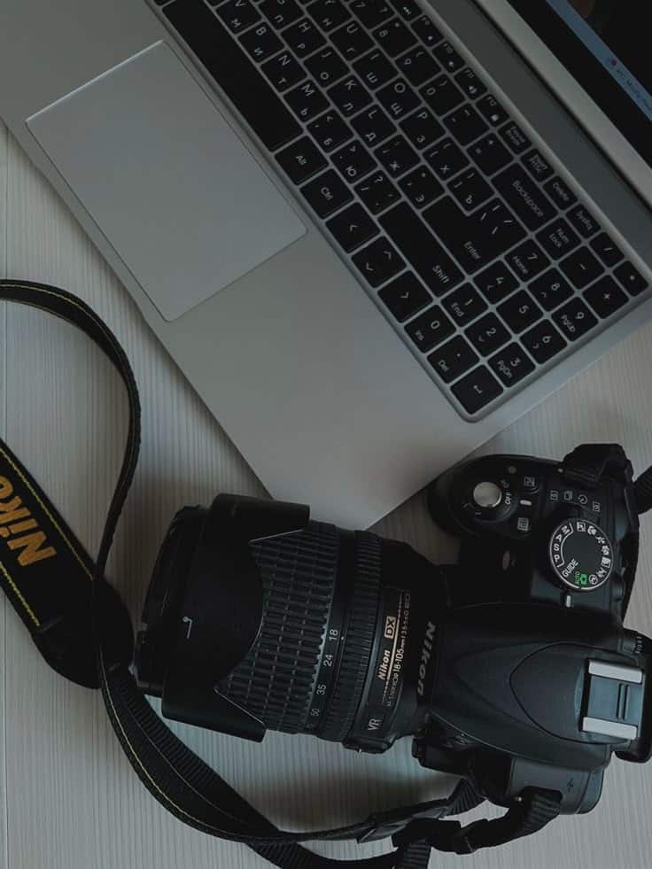 Фотоаппарат эстетика Laptop and Nikon camera on a wooden desk, capturing technology and photography tools in a creative workspace setting. | Sky Rye Design Laptop and Nikon camera on a wooden desk, capturing technology and photography tools in a creative workspace setting.