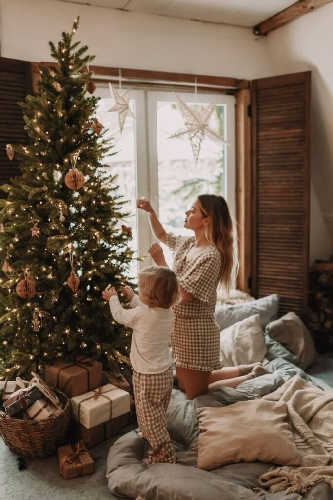 Фотограф Елена Гореликова gorelena_photo Mother and child decorating a Christmas tree in a cozy room with gifts and stars, capturing festive warmth and holiday spirit. | Sky Rye Design Mother and child decorating a Christmas tree in a cozy room with gifts and stars, capturing festive warmth and holiday spirit.