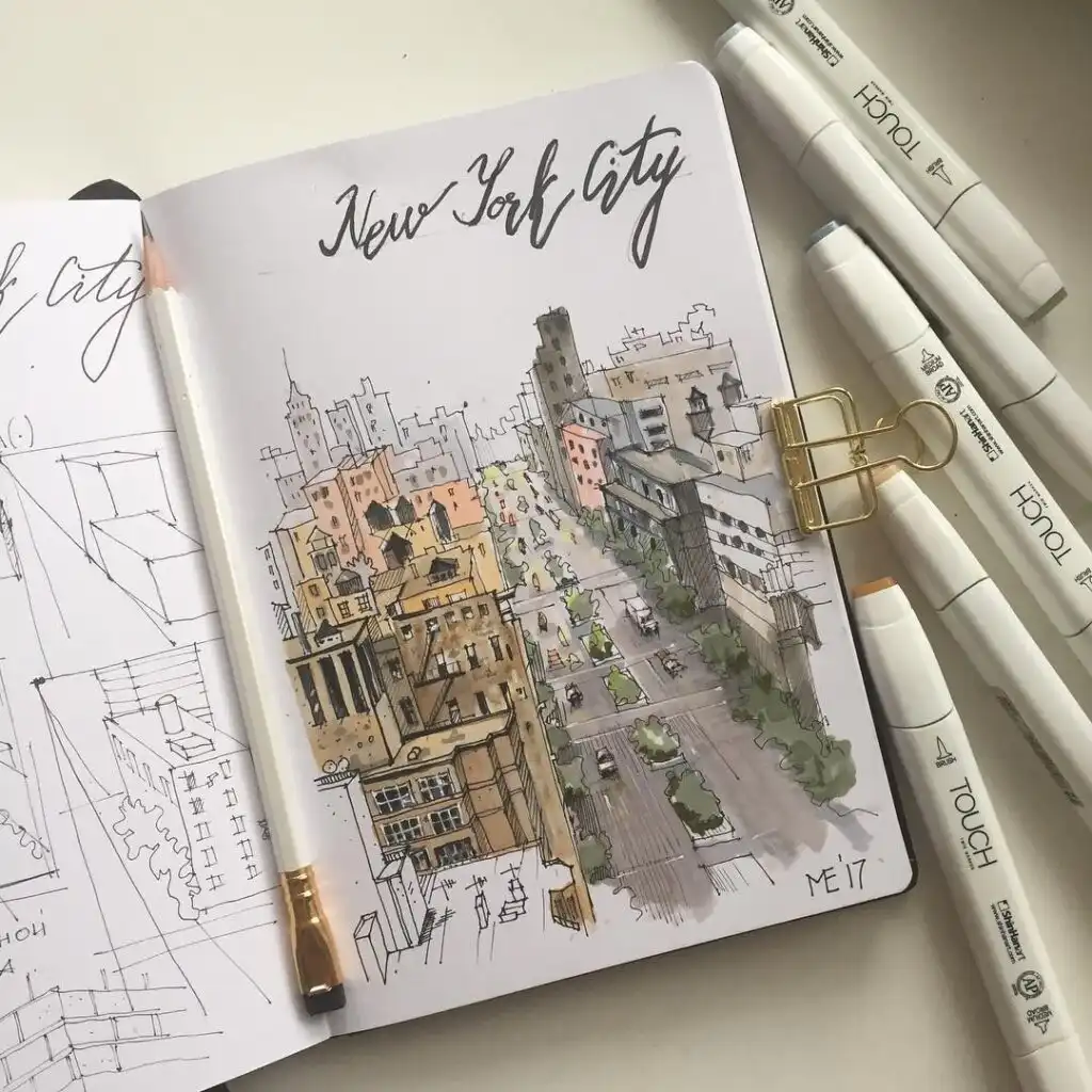 Hand-drawn sketch of New York City skyline on a notepad with colorful markers and a pencil, showcasing urban art creativity.