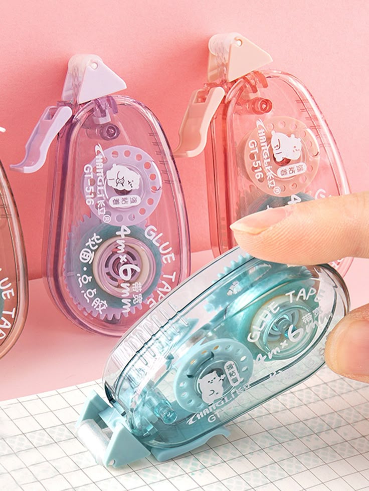 1 peça de fita adesiva de slogan gráfico aleatório Colorful glue tape dispensers with clear casings displayed on a pink background, showcasing compact design and user-friendly features. | Sky Rye Design Colorful glue tape dispensers with clear casings displayed on a pink background, showcasing compact design and user-friendly features.