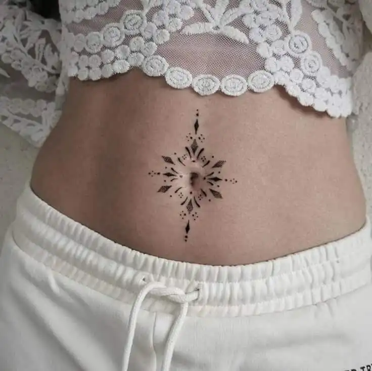 _ 100 Lace crop top and white shorts showcasing intricate belly button tattoo design on a woman's abdomen. | Sky Rye Design Lace crop top and white shorts showcasing intricate belly button tattoo design on a woman's abdomen.