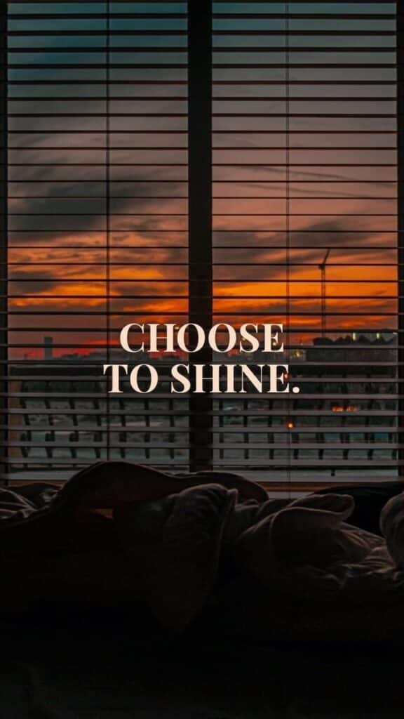 Sunset view through window blinds with motivational text Choose to Shine over a cozy interior setting.