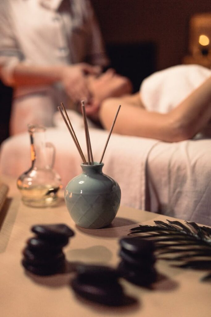 _ 14 Spa setting with aroma sticks, massage stones, and oil. Therapist giving a relaxing massage in a tranquil atmosphere. | Sky Rye Design Spa setting with aroma sticks, massage stones, and oil. Therapist giving a relaxing massage in a tranquil atmosphere.
