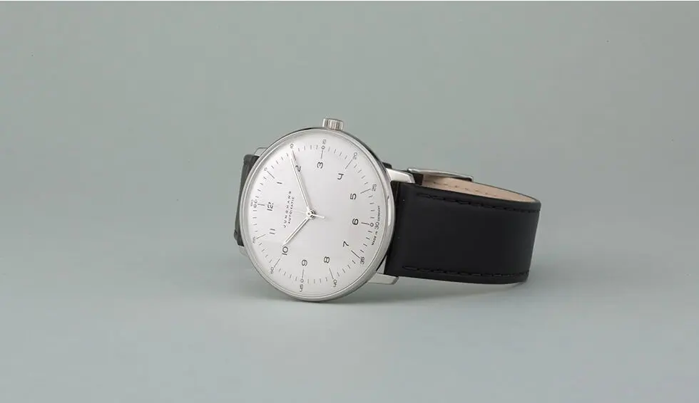 Minimalist silver watch with a white face and black leather strap on a gray background, showcasing elegant timepiece design.