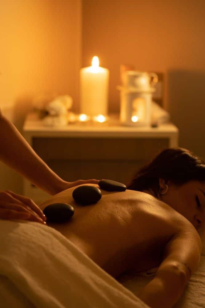 _ 17 Woman enjoying a relaxing hot stone massage in a cozy, candlelit spa setting for soothing relaxation and stress relief. | Sky Rye Design Woman enjoying a relaxing hot stone massage in a cozy, candlelit spa setting for soothing relaxation and stress relief.