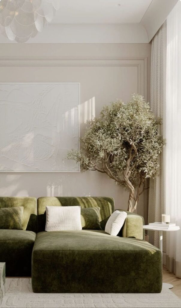 _ 18 Cozy living room with a green velvet sofa, white cushions, large indoor plant, stylish wall art, and natural light through curtains. | Sky Rye Design Cozy living room with a green velvet sofa, white cushions, large indoor plant, stylish wall art, and natural light through curtains.
