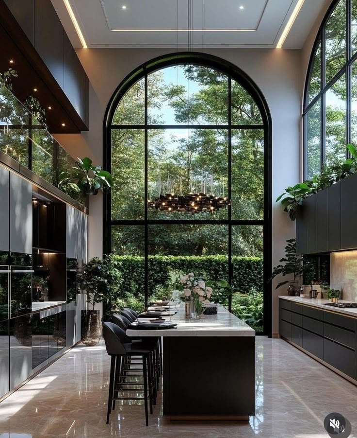 _ 20 Modern kitchen with large arched windows, island, bar stools, and lush green view, combining elegance and nature for a bright, airy space. | Sky Rye Design Modern kitchen with large arched windows, island, bar stools, and lush green view, combining elegance and nature for a bright, airy space.