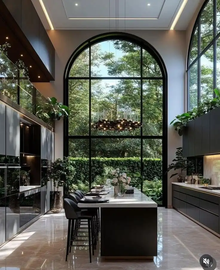 _ 20 Modern kitchen with large arched windows, island, bar stools, and lush green view, combining elegance and nature for a bright, airy space. | Sky Rye Design Modern kitchen with large arched windows, island, bar stools, and lush green view, combining elegance and nature for a bright, airy space.