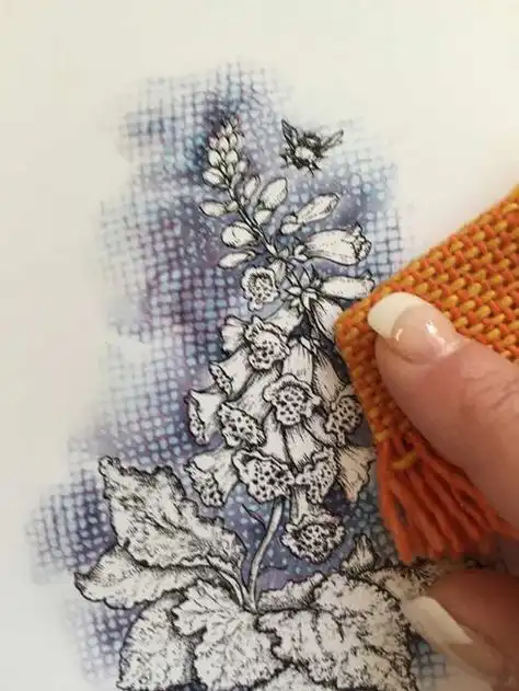 Hand holding an orange textile near a detailed botanical sketch of a flowering plant, accompanied by a bee illustration on a textured background.
