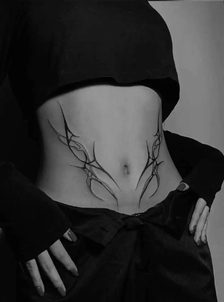_ - 2026-01-04T191312054 Black and white photo of a lower abdomen with a tribal tattoo design, showing artistic ink patterns and style. | Sky Rye Design Black and white photo of a lower abdomen with a tribal tattoo design, showing artistic ink patterns and style.