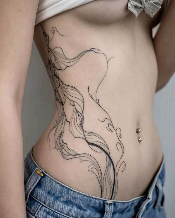 _ - 2026-01-04T192241187 Elegant side tattoo design with flowing lines on a woman's torso. She wears blue jeans and has a navel piercing. | Sky Rye Design Elegant side tattoo design with flowing lines on a woman's torso. She wears blue jeans and has a navel piercing.