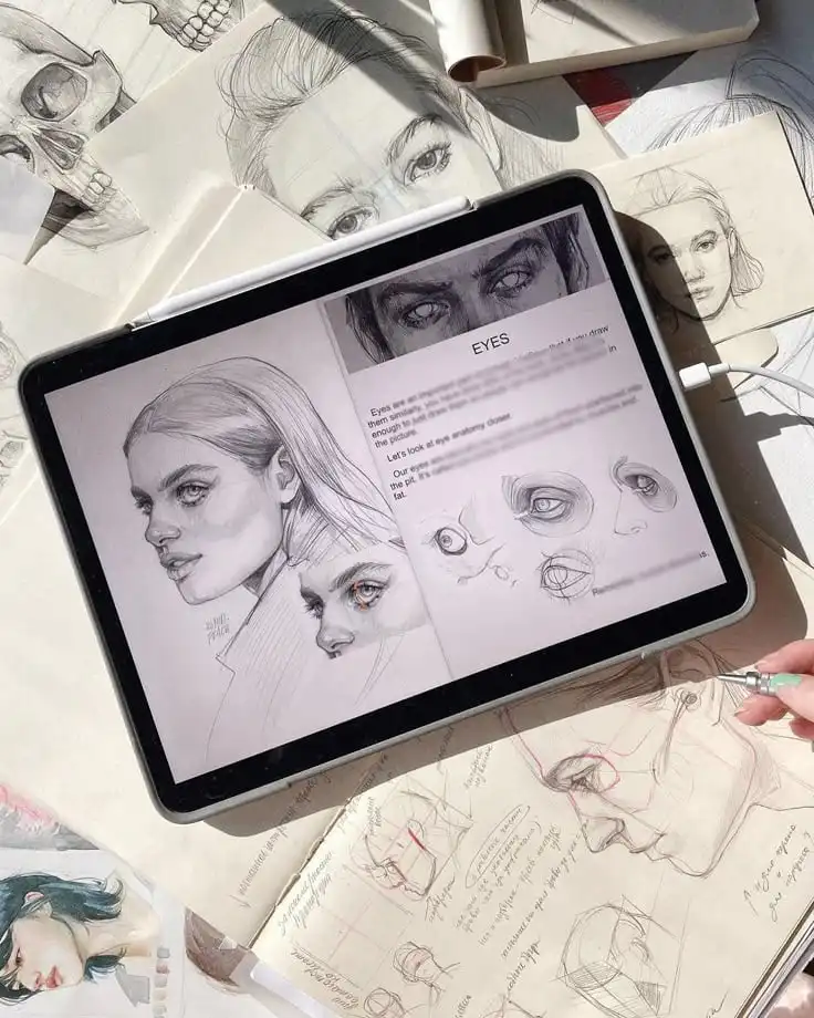 Digital and paper sketches of faces and eyes, highlighting artist’s detailed drawings and study notes on anatomy and expression.