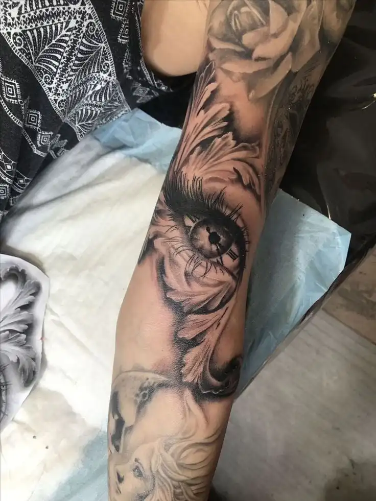 _ - 2026-01-10T233501621 Intricate arm tattoo featuring a detailed eye, rose, and woman's face in vibrant black and gray ink, showcasing artistic design. | Sky Rye Design Intricate arm tattoo featuring a detailed eye, rose, and woman's face in vibrant black and gray ink, showcasing artistic design.