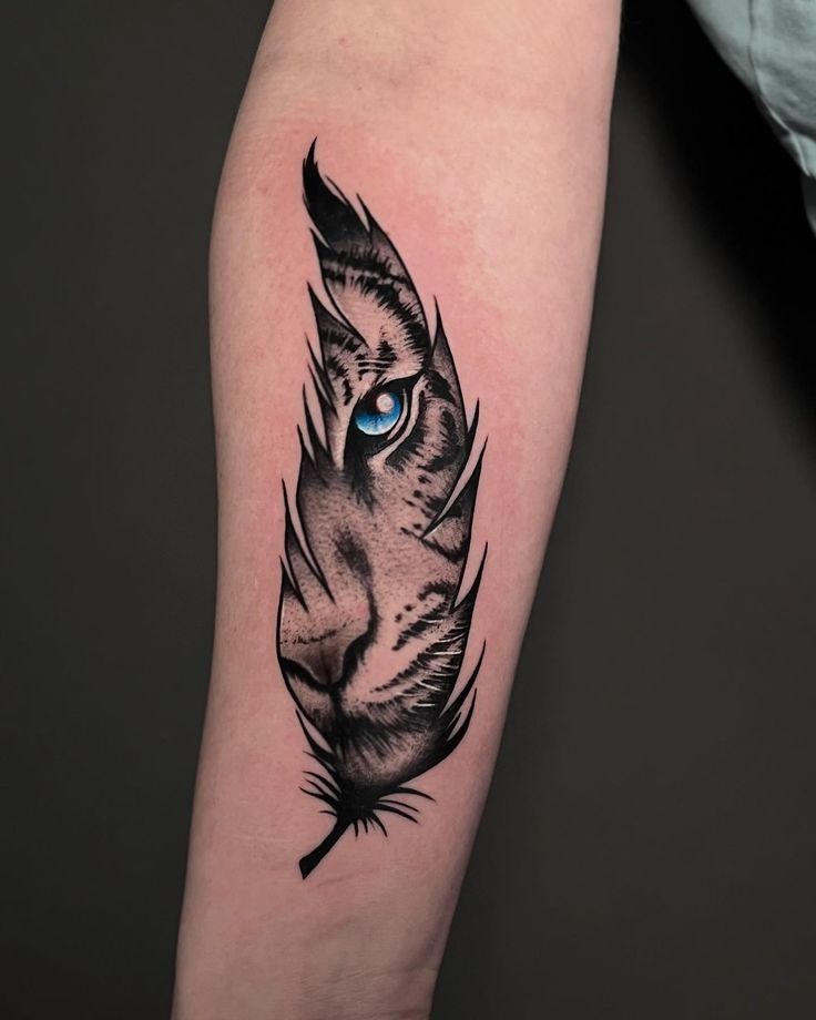 _ - 2026-01-10T233655653 Tattoo of a feather with a detailed tiger face and blue eye on the inside of an arm. Unique design blends nature and animal art. | Sky Rye Design Tattoo of a feather with a detailed tiger face and blue eye on the inside of an arm. Unique design blends nature and animal art.