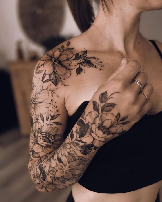 22 Creative Sleeve Tattoo Ideas for Women Floral tattoo sleeve on a woman's arm and shoulder, featuring intricate flower designs, captured indoors with soft lighting. | Sky Rye Design Floral tattoo sleeve on a woman's arm and shoulder, featuring intricate flower designs, captured indoors with soft lighting.