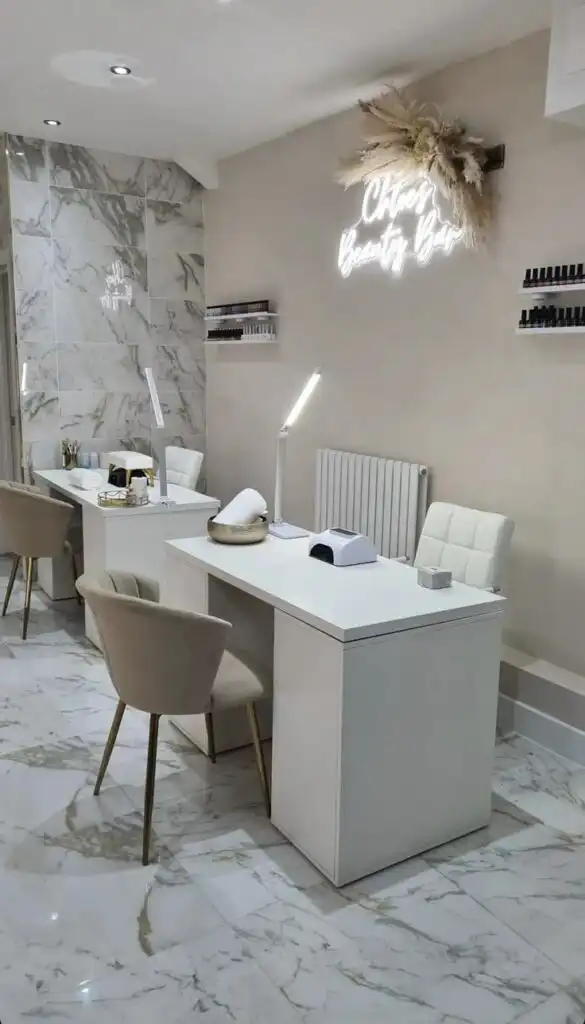 Chic beauty salon interior with marble floors, stylish manicure stations, and elegant lighting, creating a serene and modern atmosphere.