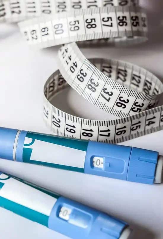 _ 3 Close-up of insulin pens and a coiled measuring tape, symbolizing diabetes management and health awareness. | Sky Rye Design Close-up of insulin pens and a coiled measuring tape, symbolizing diabetes management and health awareness.