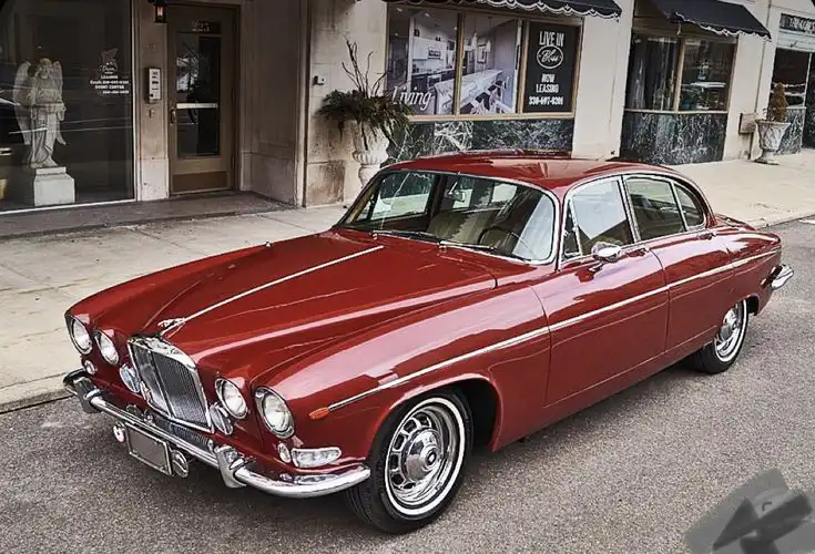 Vintage red classic car parked on a city street, showcasing elegant curves and chrome details, with storefronts in the