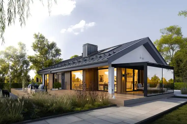 Modern single-story home with large windows, outdoor terrace, and garden in a serene setting at sunset. Perfect blend of