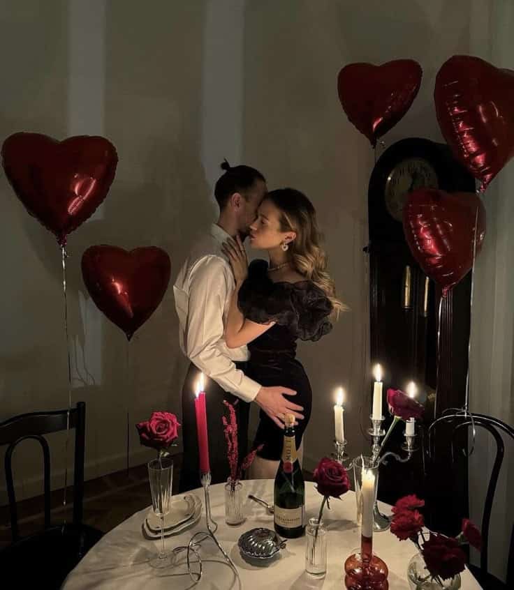 Screenshot Romantic candlelit dinner setting with a couple embracing, surrounded by heart-shaped balloons and roses. | Sky Rye Design Romantic candlelit dinner setting with a couple embracing, surrounded by heart-shaped balloons and roses.