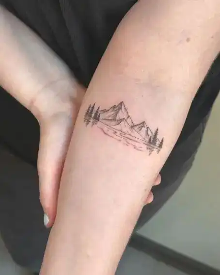 50 Beautiful Mountain Tattoo Ideas For Every Aesthetic In 2025 Minimalist mountain and forest tattoo on forearm, showcasing nature-inspired art in black ink. | Sky Rye Design Minimalist mountain and forest tattoo on forearm, showcasing nature-inspired art in black ink.