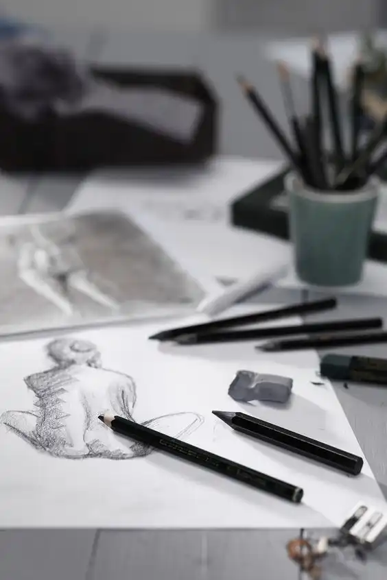 Artistic scene with sketches, drawing pencils, and erasers on a desk, showcasing creative pencil drawing and sketching tools.