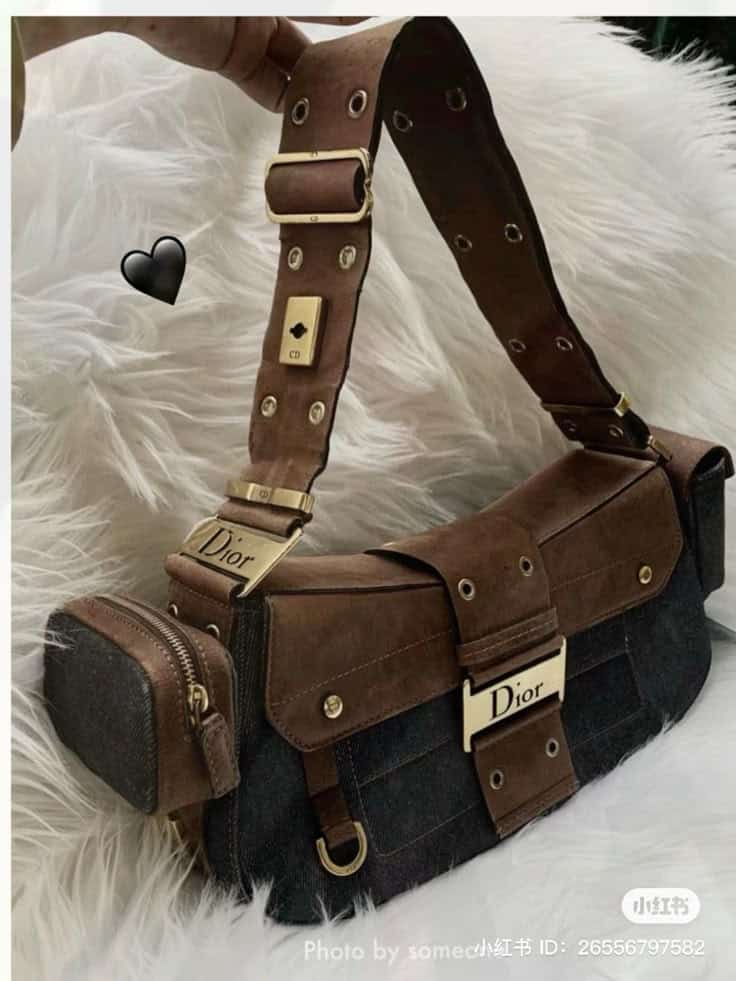 _ 87 Brown designer handbag with gold accents and denim details on a white faux fur background. | Sky Rye Design Brown designer handbag with gold accents and denim details on a white faux fur background. 2026 Bag Trends