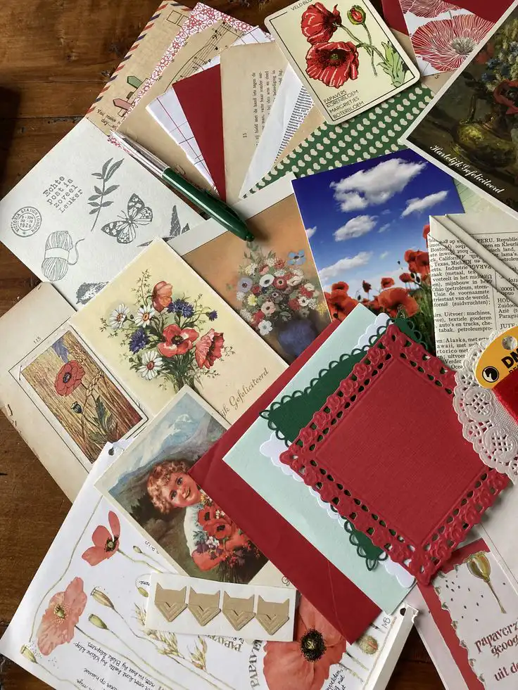 Colorful scrapbook materials and postcards with floral designs, featuring poppies, perfect for crafting or DIY art projects.