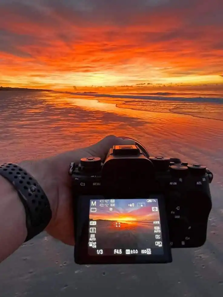 9e72be44-d9f0-43f8-80e7-b7667a6dbc5f Camera captures stunning beach sunset with vibrant orange and pink clouds reflected on wet sand, highlighting nature’s beauty. | Sky Rye Design Camera captures stunning beach sunset with vibrant orange and pink clouds reflected on wet sand, highlighting nature’s beauty.
