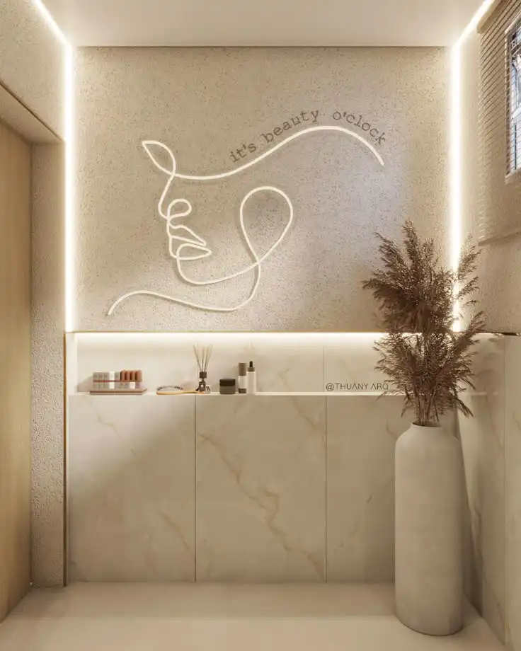 Minimalist room with abstract line art and it's beauty o'clock neon sign. Features marble tiles, dried plant, and beauty products.